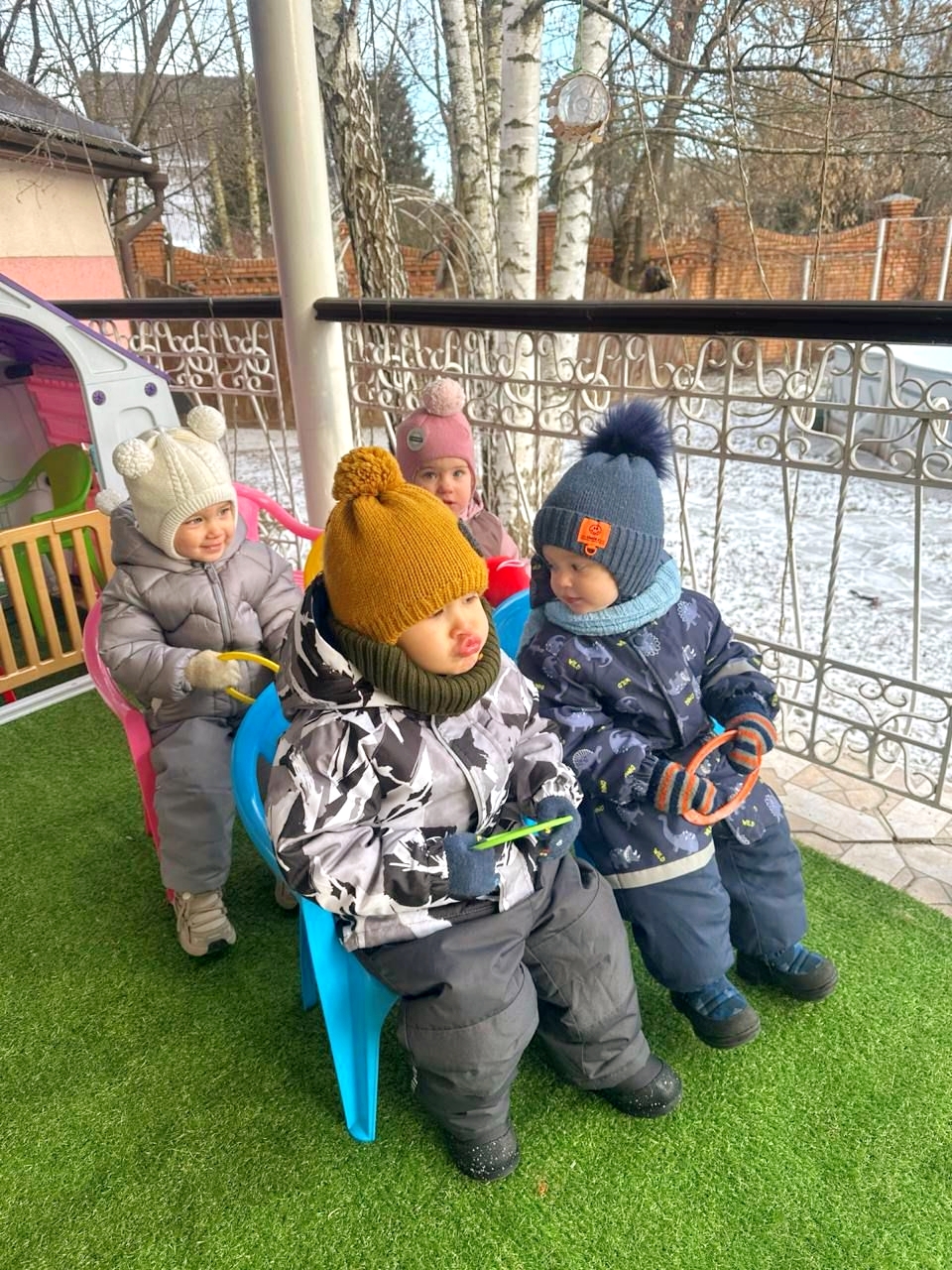 Малыши на зимней прогулке на веранде сада